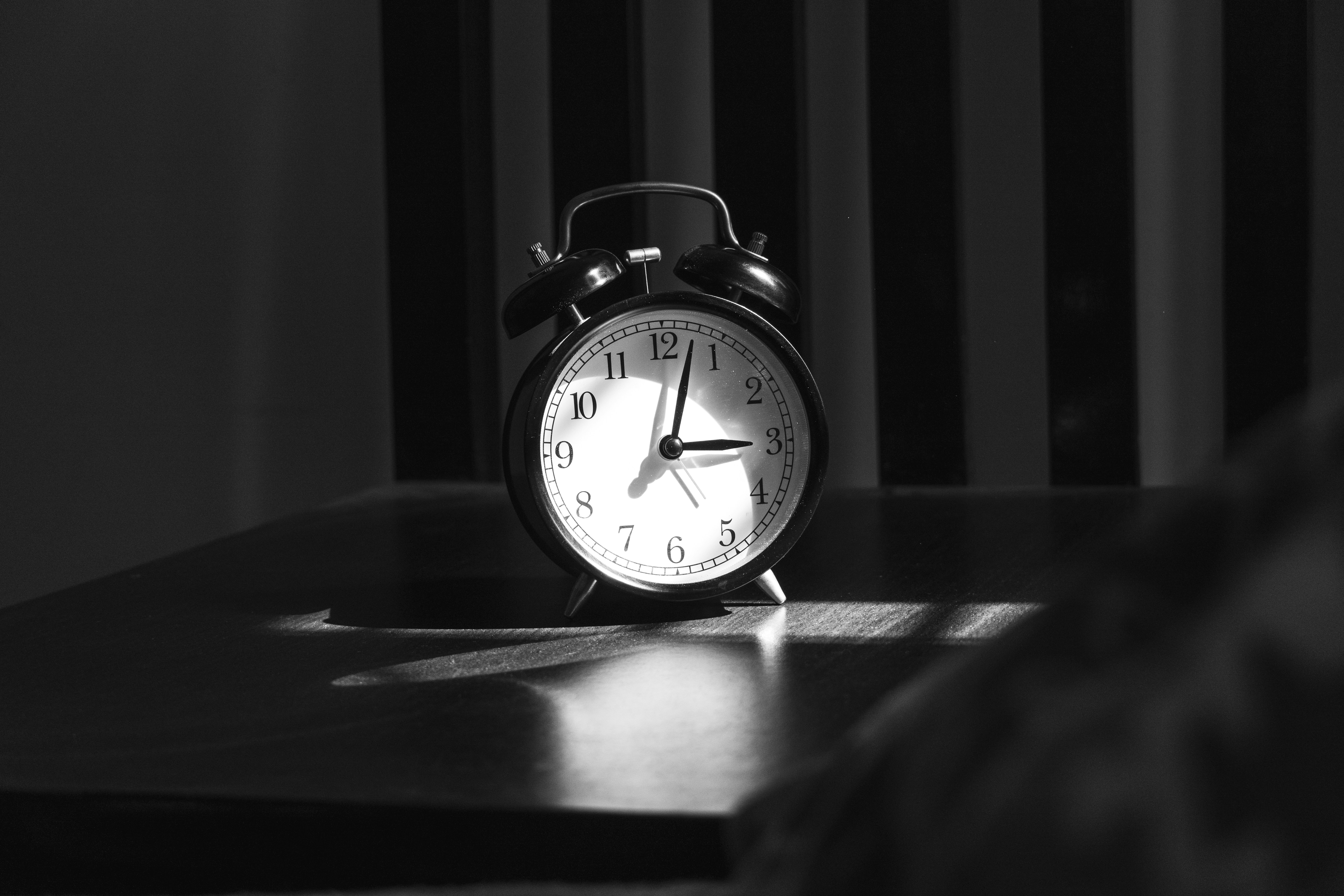 Reloj despertador sobre una superficie oscura marcando una hora avanzada de la noche